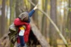 Pfadfinder beim Wandern im Herbstwald. Hinter dem Kind befindet sich eine Tipi-Hütte. Abenteuer