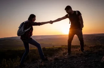 Silhouette in Bergen, Sonnenaufgang. Teamwork von Mann und Frau Wanderer