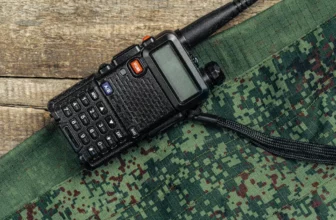 Walkie-Talkie und Militäruniform auf Holzoberfläche