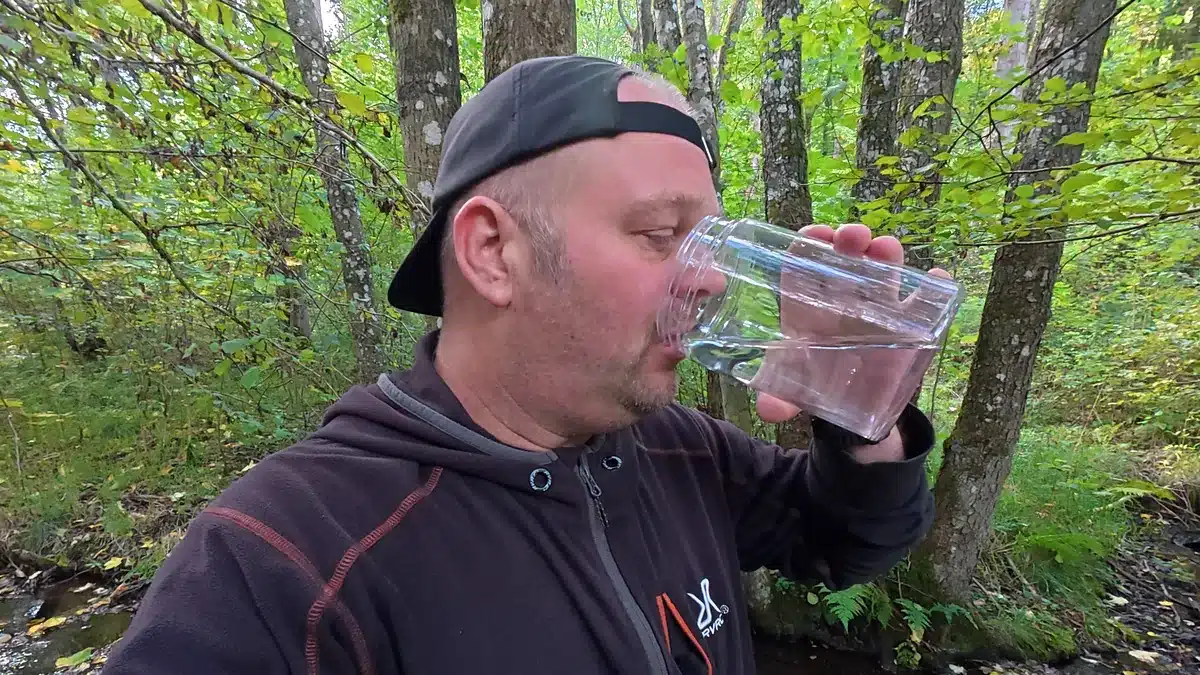 Robert trinkt am Bach das mit dem ITEHIL Mini gefilterte Wasser